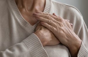 Picture of a woman with pulmonary hypertension holding her chest.
