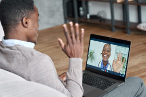 Male Black Patient Talking On Conference Video Call To Female Af
