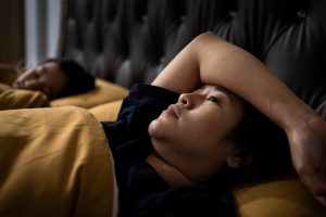 Picture of a woman lying awake in bed at night.