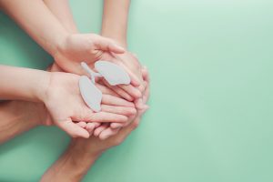 Picture of two people holding a paper cutout of a set of lungs in their hands.